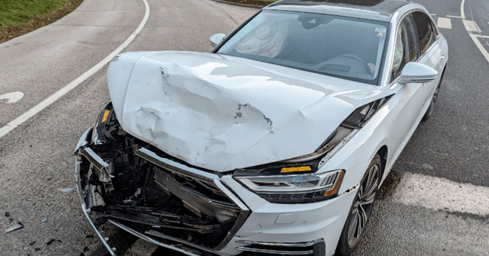 Severely damaged white sedan with crushed front end after a roadway collision, representing insurance inspection and Total Loss Threshold South Carolina following a serious auto accident.